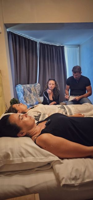 Calogero Grifasi durante una sesión formativa Academy de hipnosis regresiva esotérica Método Grifasi, tomando notas con dos participantes en trance